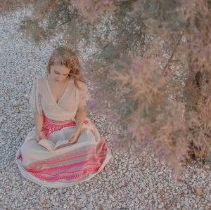 High angle portrait of young woman sitting outdoors