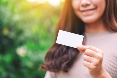 Close-up portrait of a smiling young woman holding hands