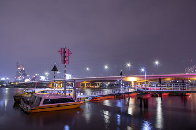 View of illuminated bridge over river at night