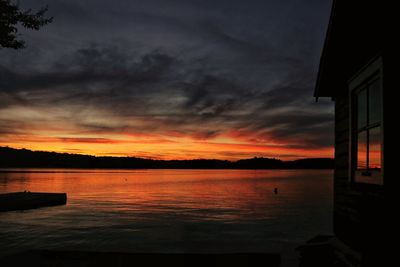 Scenic view of sea against dramatic sky during sunset