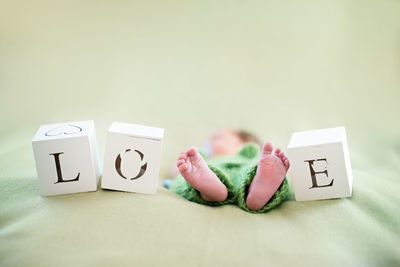 Newborn child sleeping amidst toy blocks with alphabets on bed