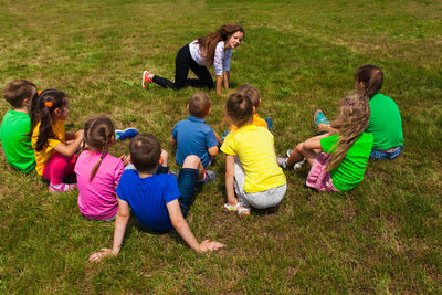 Rear view of people enjoying on grass