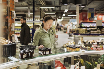 Thoughtful female customer shopping at supermarket