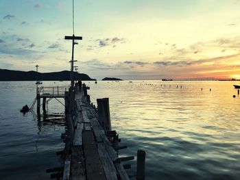 Pier over sea against sky during sunset