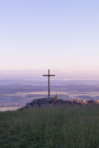 Lifeguard hut on field against sky during sunset