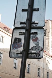 Low angle view of road sign against buildings in city