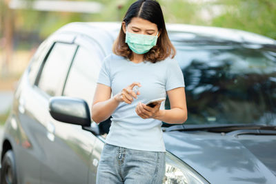 Full length of woman holding mobile phone in car