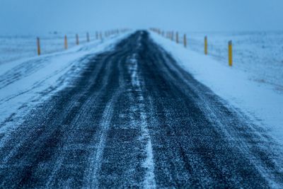 Tire tracks on snow against sky