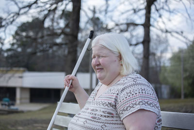 Albino woman sitting on a park bench