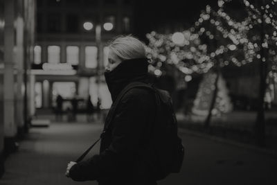 Rear view of woman walking on street at night