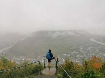 Rear view of man on mountain against sky