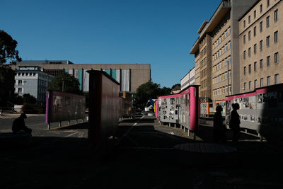 People on street against buildings in city