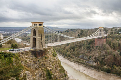 Bridge over river against cloudy sky