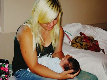 Young woman with daughter on bed at home