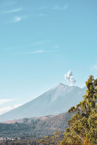 Scenic view of snowcapped mountains against blue sky