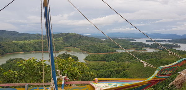 Scenic view of river by mountains against sky
