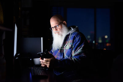 Man using mobile phone while sitting on table