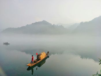 High angle view of man in boat on lake against sky