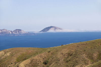 Scenic view of sea and mountains against sky