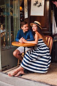 Young couple sitting on chair at restaurant