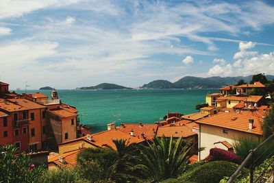 High angle view of houses by sea against sky