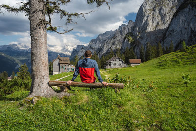 Rear view of man sitting on field