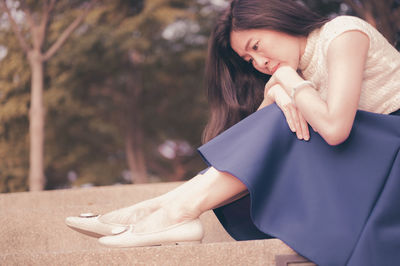 Low section of woman sitting outdoors