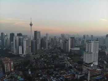 Aerial view of buildings in city at sunset