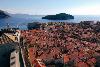 High angle view of town by sea against clear sky