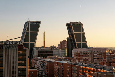 Buildings in city against sky during sunset