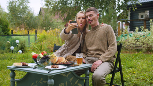 Couple talking on video call while having lunch outdoors