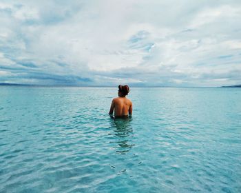 Rear view of two young woman swimming in sea