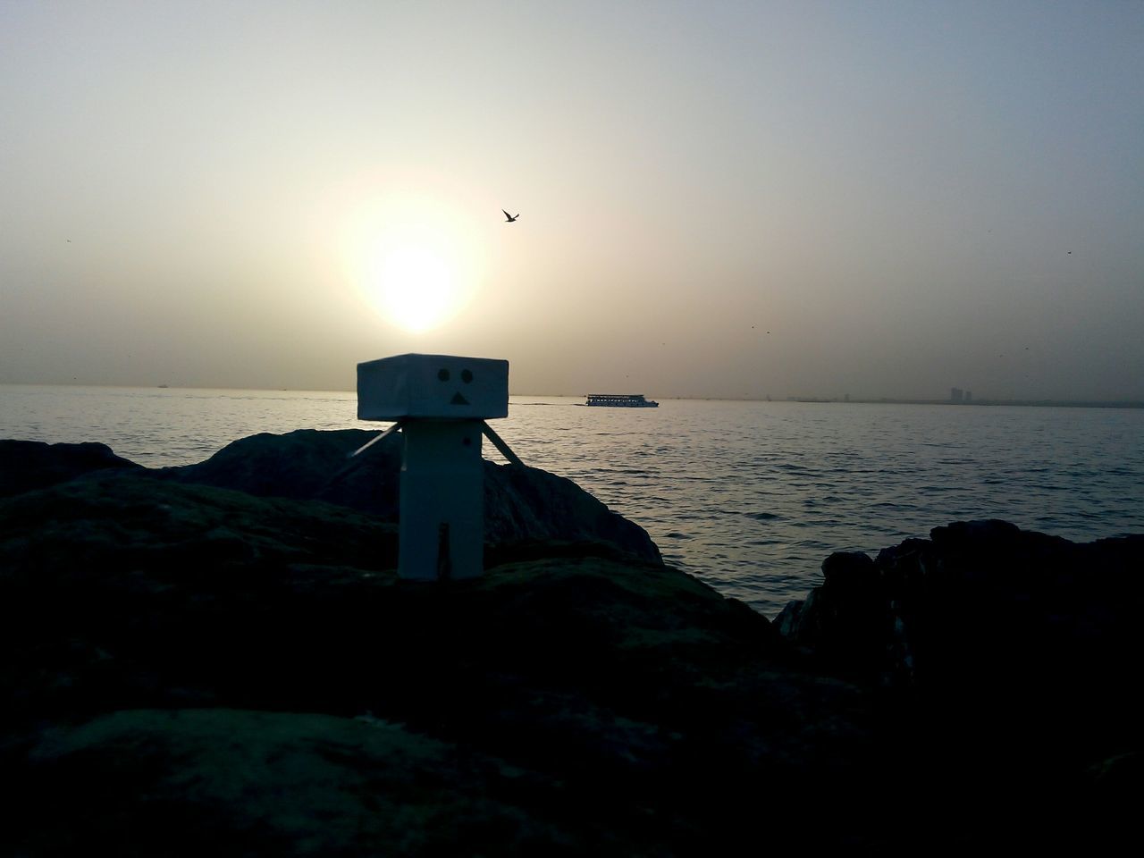 sea, horizon over water, water, sunset, sun, scenics, tranquility, tranquil scene, clear sky, lighthouse, guidance, beauty in nature, silhouette, copy space, nature, idyllic, sky, built structure, protection, rock - object