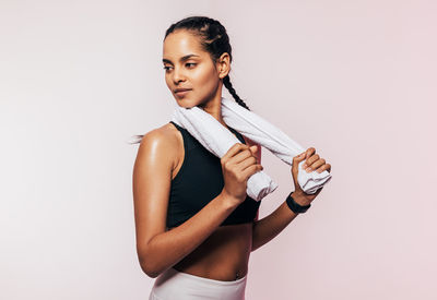 Young woman standing against white background