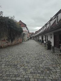 Cobblestone street amidst buildings against sky