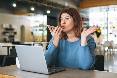 Beautiful young woman plus size body positive using laptop at beauty salon office, small business