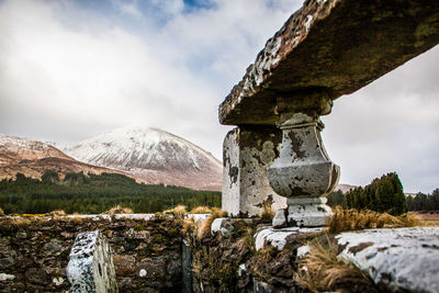 Built structure on snow covered mountain against sky