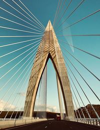 Low angle view of suspension bridge against sky