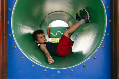 Funny child inside a tube in a playground game