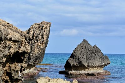 Close-up of rocks on shore against sky