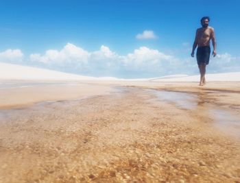 Full length of man standing on beach against sky