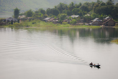 People on lake against plants