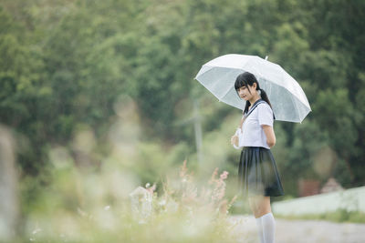 Woman with umbrella standing in rain