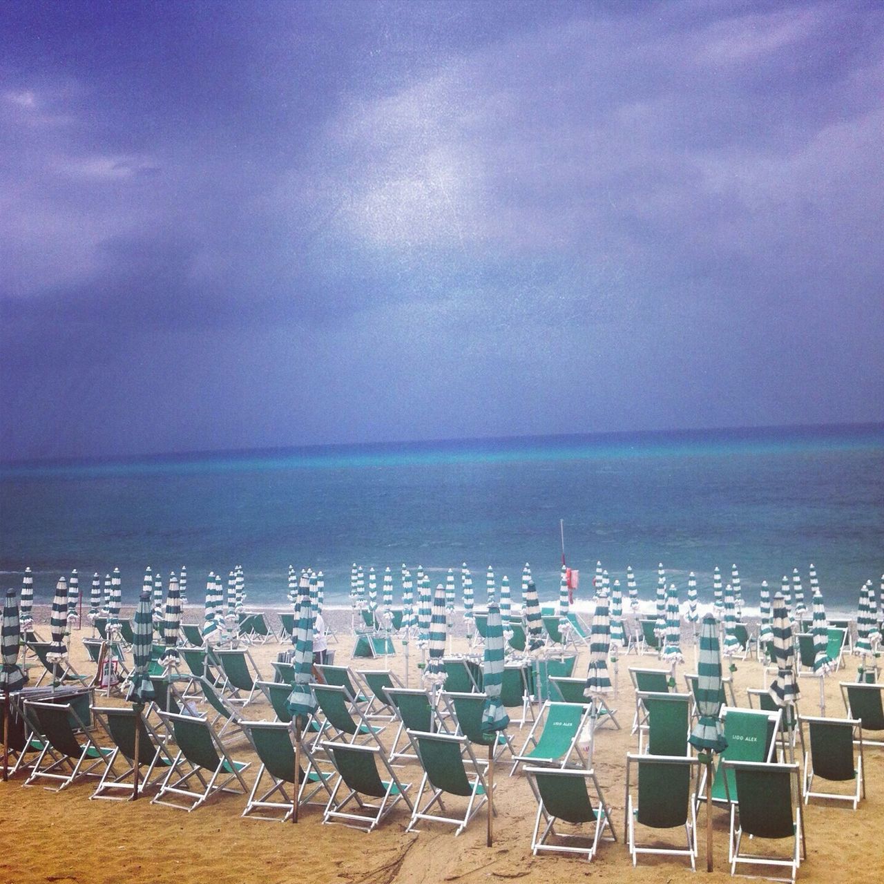 sea, horizon over water, water, sky, beach, tranquil scene, scenics, tranquility, shore, chair, cloud - sky, nature, absence, sand, beauty in nature, blue, deck chair, lounge chair, vacations, ocean