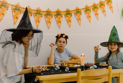 Three girls eating halloween pasta at the table.