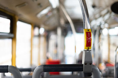 Bus interior in circulation with the stop button in the foreground on a blurred background.