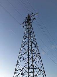 Low angle view of silhouette electricity pylon against clear sky