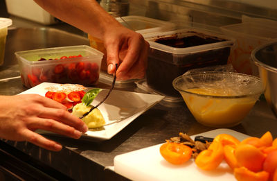 Midsection of person preparing food in kitchen