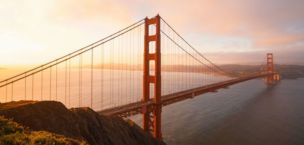 Aerial view of golden gate bridge over bay against sky