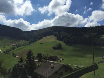 Scenic view of landscape and houses against sky